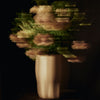 Blurred bouquet of soft pink flowers in a sleek white vase against a dark background. Elegant and artistic design.