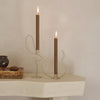 "Modern candle holders in neutral tones with elegant brown candles, featuring abstract, curvy designs."