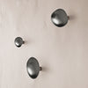 Stylish matte black wall hooks in varied sizes, showcasing sleek, modern shapes against a soft beige background.