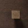 Bronze square knob with a textured finish on a dark wood background. Perfect for modern cabinetry.