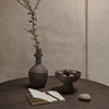 "Textured brown pottery vase and bowl with natural stones, featuring earthy tones and subtle striped patterns."