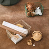 "Metal wire storage baskets in green and white, surrounded by neutral-toned decor on a brown rug."
