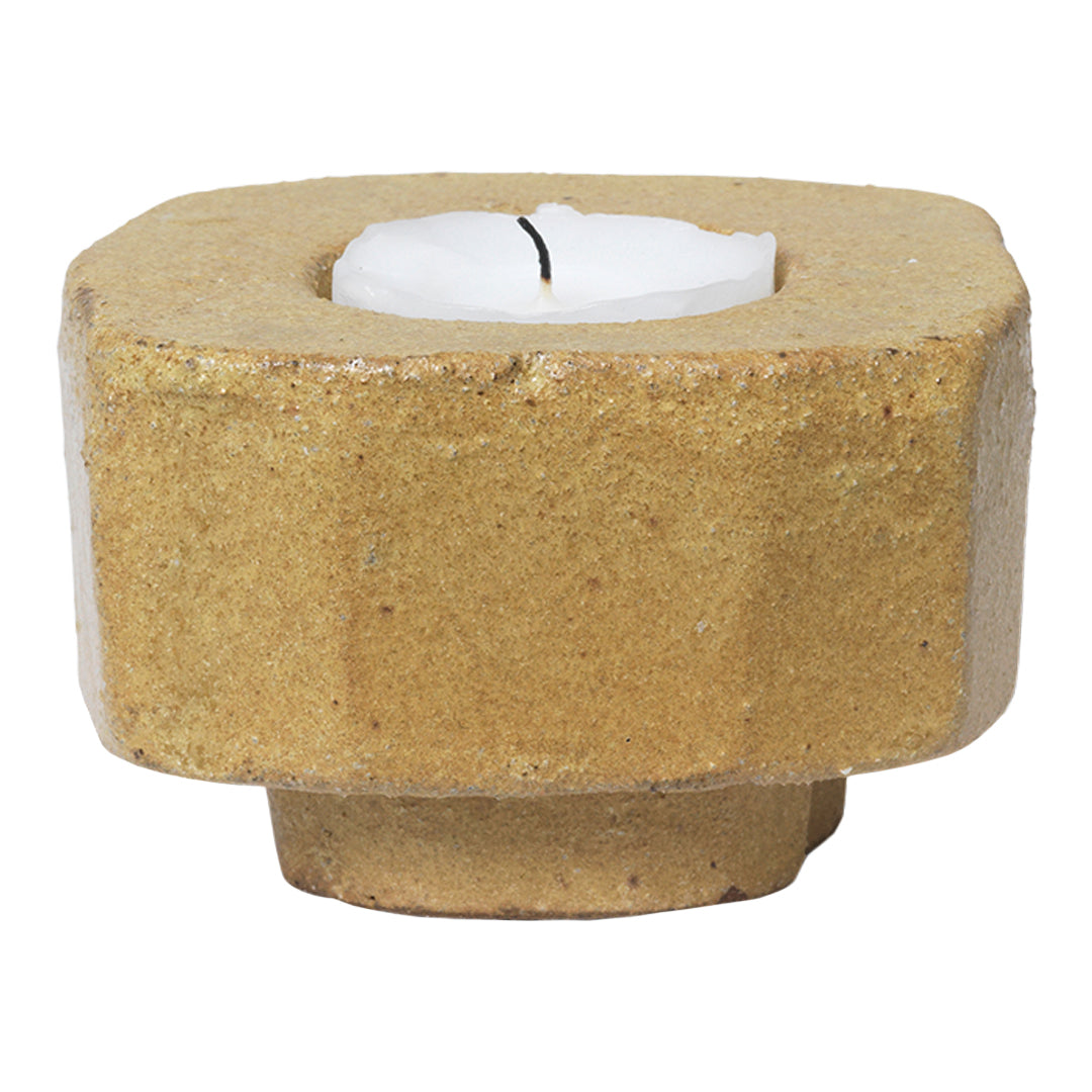 Natural textured yellow candle holder with a geometric design, featuring a minimalist white candle on top.