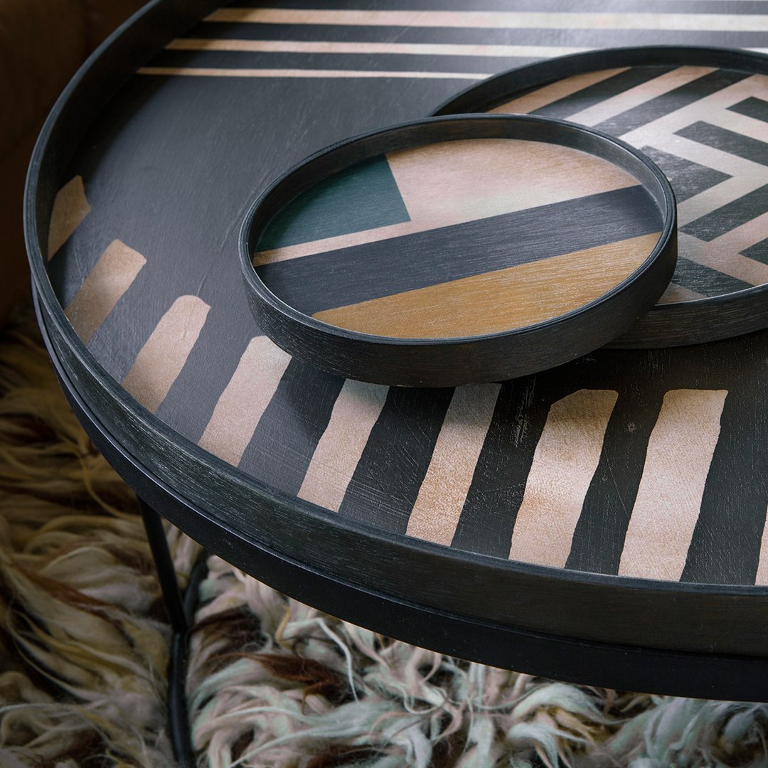 "Geometric patterned tabletop in black, beige, teal, and wood finishes, featuring circular and linear designs."