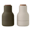 "Two modern bottles: one in olive green, the other in soft white, with natural wood lids and smooth matte finishes."