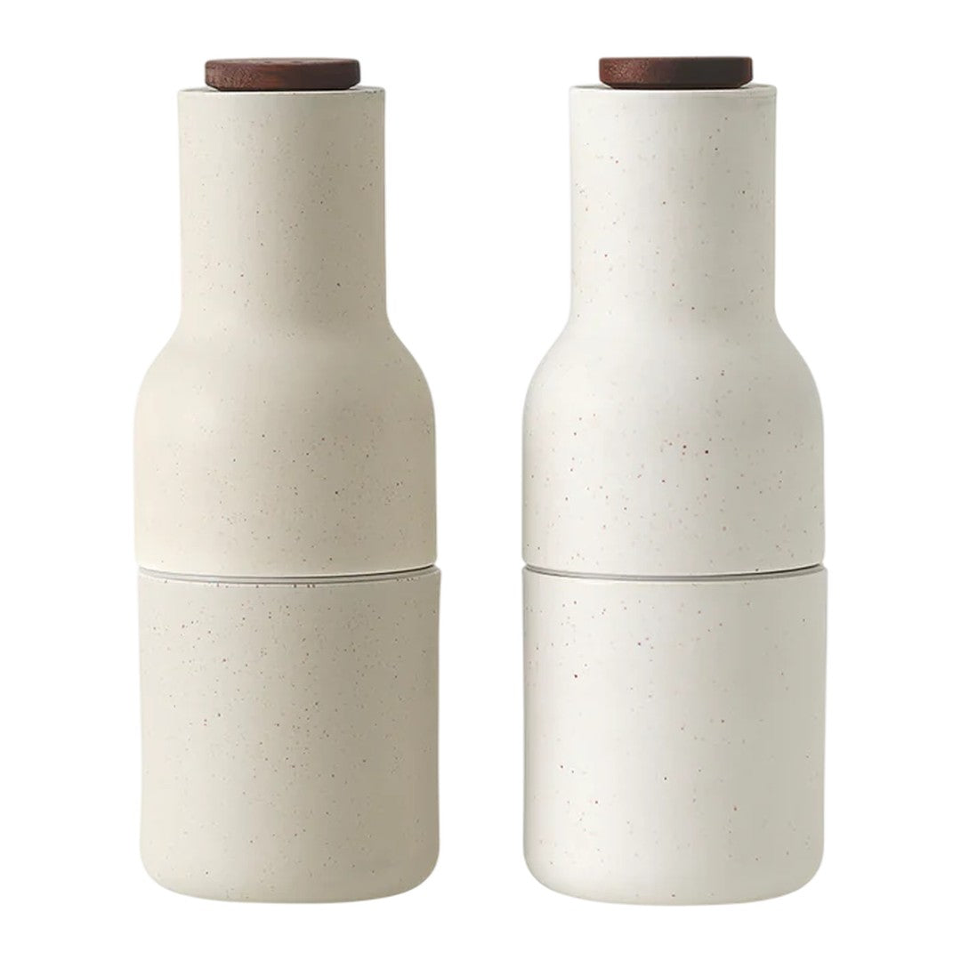 Neutral beige ceramic salt and pepper shakers with smooth textures and natural wooden tops.