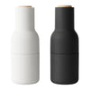 Matte black and white spice grinder set with natural wood tops, sleek modern design. Perfect for kitchen decor.