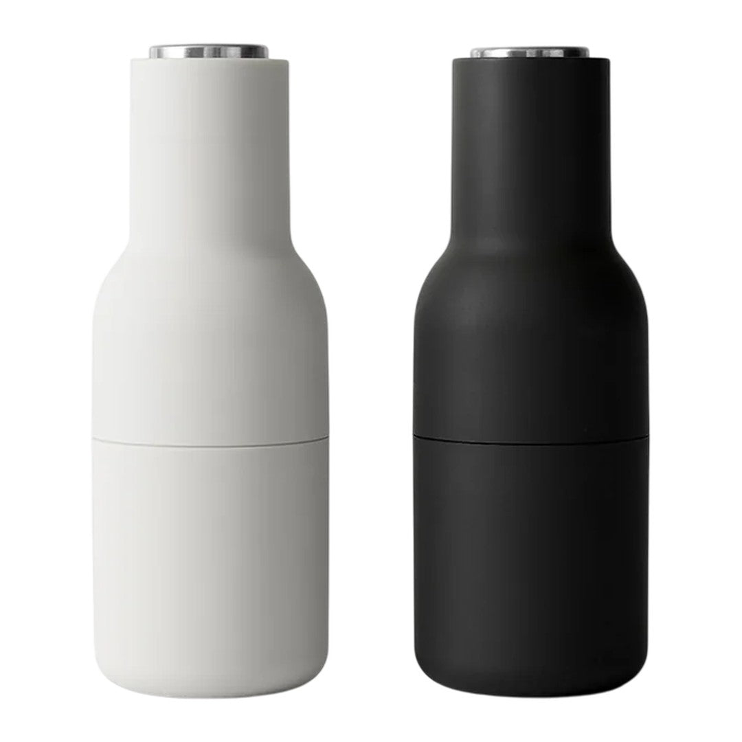 Modern salt and pepper shakers in sleek matte black and white finishes with minimalist design. Perfect for any table setting.