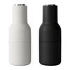 Modern salt and pepper shakers in sleek matte black and white finishes with minimalist design. Perfect for any table setting.
