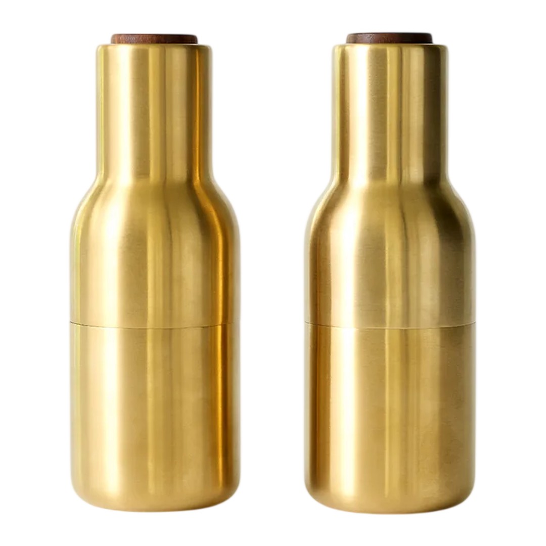 Brushed gold pepper mills with a sleek, modern design and smooth, shiny finish. Elegant wooden tops add contrast.