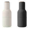 "Two sleek bottles in matte white and matte black with wooden accents, showcasing modern design and minimalistic patterns."
