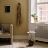 Cozy beige wall with a textured cream sofa and a dark, patterned side table accent. Natural light highlights earthy tones.