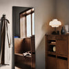 "Minimalist mirror in a warm-toned room with neutral décor, soft lamp, and wooden furniture accents."