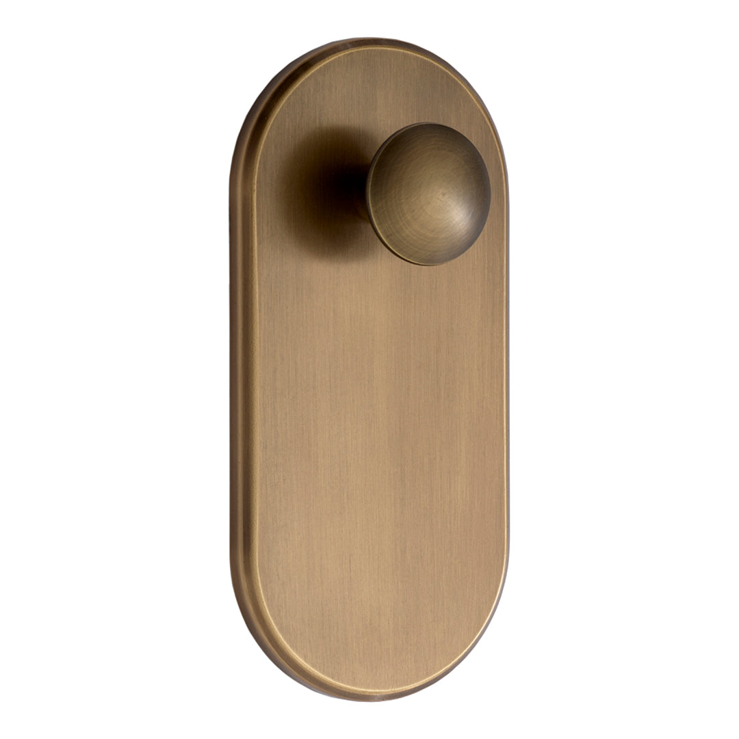 Brushed antique brass door knob with a smooth, oval plate design and round knob for a classic, elegant look.