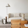 Neutral beige sofa with minimalist geometric patterns, complemented by natural wood surfaces and soft gray accents.