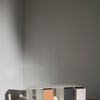 Modern open shelf featuring a mix of white, gray, and warm peach colors. Minimalist design with block patterns.
