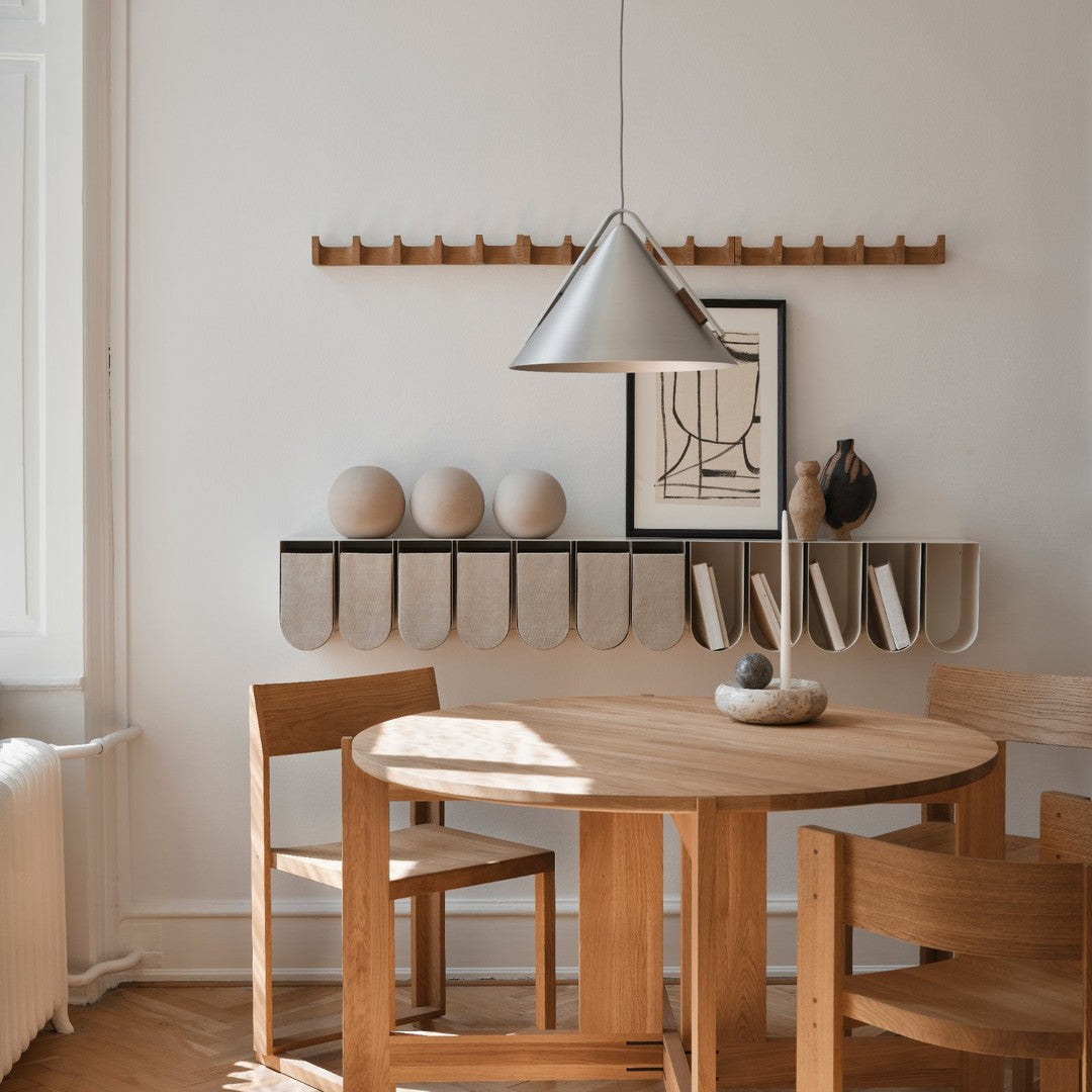 Modern wooden dining set with light tones, featuring a gray pendant light and white decorative accents. 