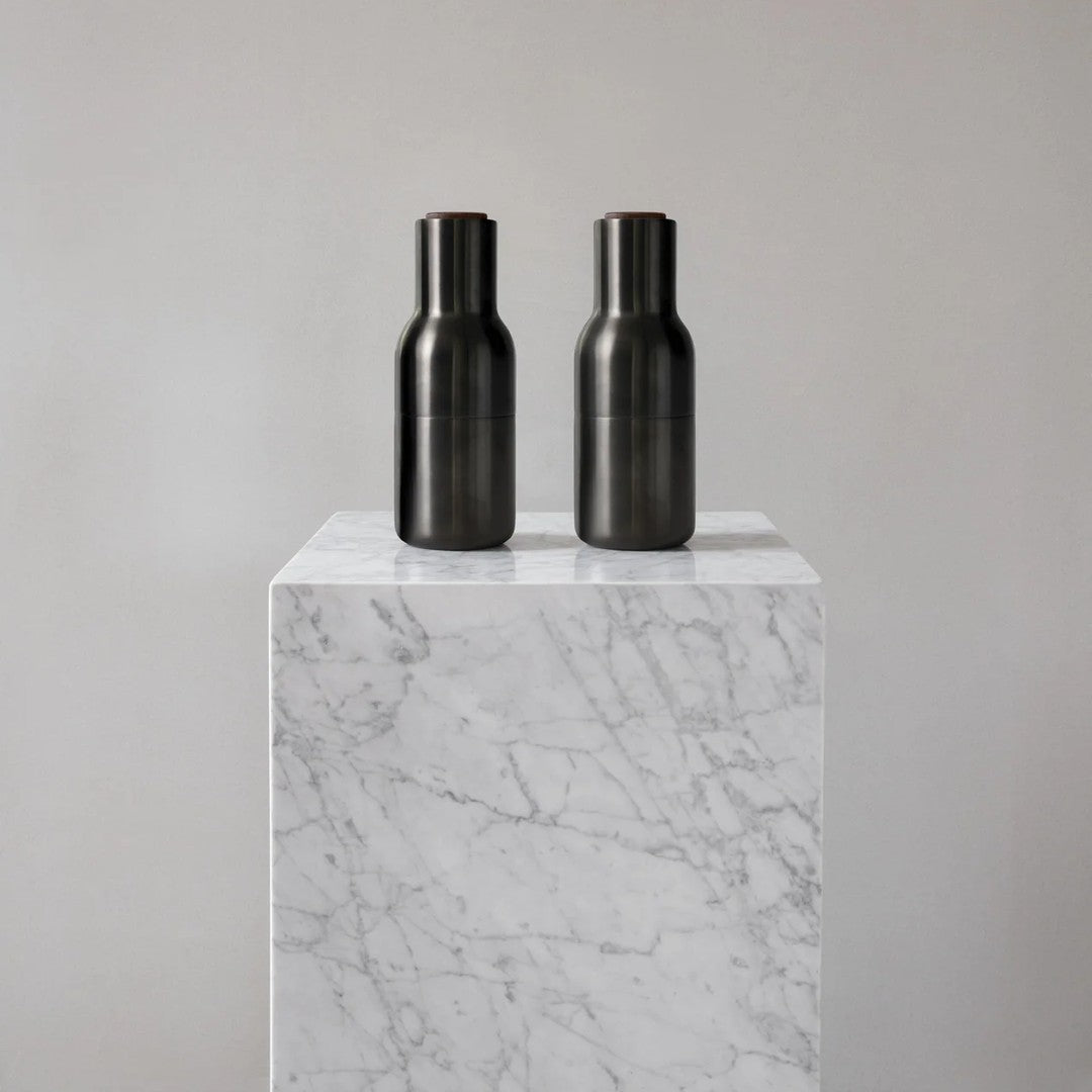 Two sleek black vases on a white marble pedestal, showcasing a modern, minimalistic design.