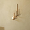 Gold wall sconces with white candles against a soft beige wall, creating an elegant, minimalist aesthetic.
