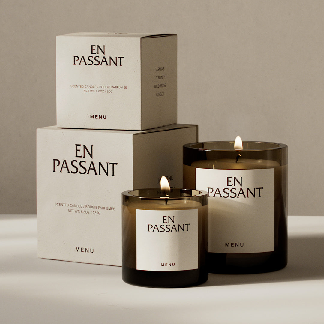 "Brown glass candle holders with cream labels, stacked boxes in soft beige, minimalist design, elegant patterns."