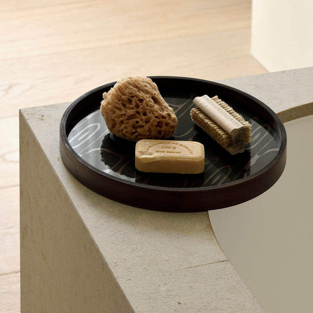 Black round tray with elegant gold patterns, minimalist design complementing natural textures and neutral tones.