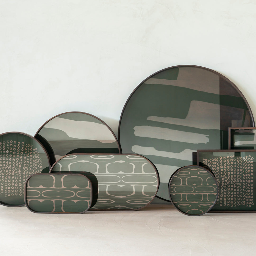 Green and beige decorative trays with abstract patterns and varying shapes, perfect for modern home decor.