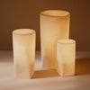"Set of three warm, matte beige lamps with soft, rounded edges and subtle geometric patterns."