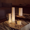 Cream-colored geometric lamps with a soft glow on a dark, marbled tabletop.