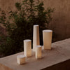 Soft, neutral-toned cylindrical candle holders with smooth finishes, showcasing elegant simplicity and modern design.