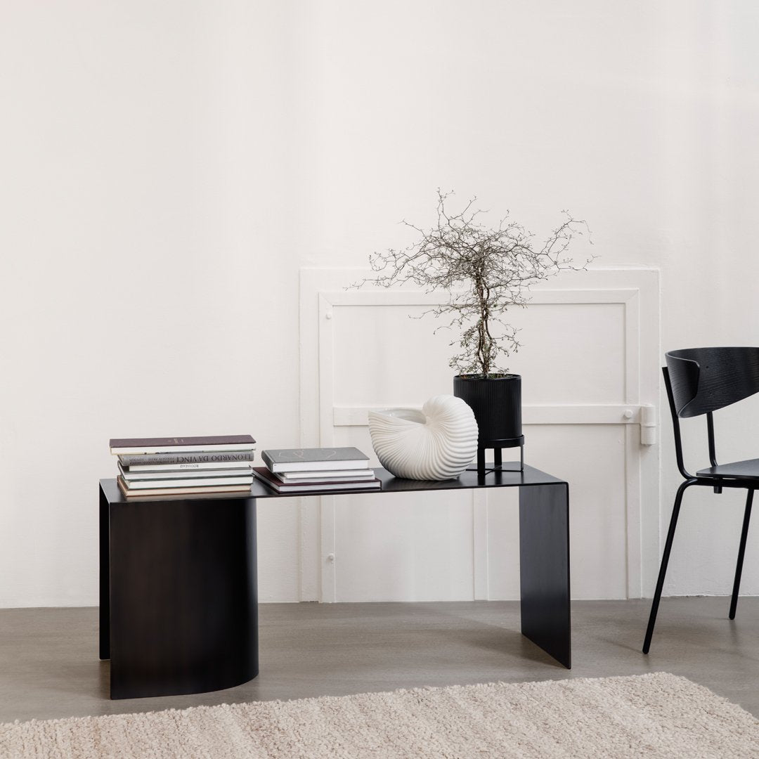 "Stylish black coffee table with a minimalist design, featuring sleek lines and a smooth surface."