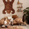 "Leopard print wall hanging with brown tones, cozy tan bedding, and earthy decor elements in a stylish bedroom setting."