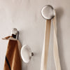 Modern metallic wall hooks with beige and brown fabric hanging, showcasing a minimalist design. Perfect for any decor.