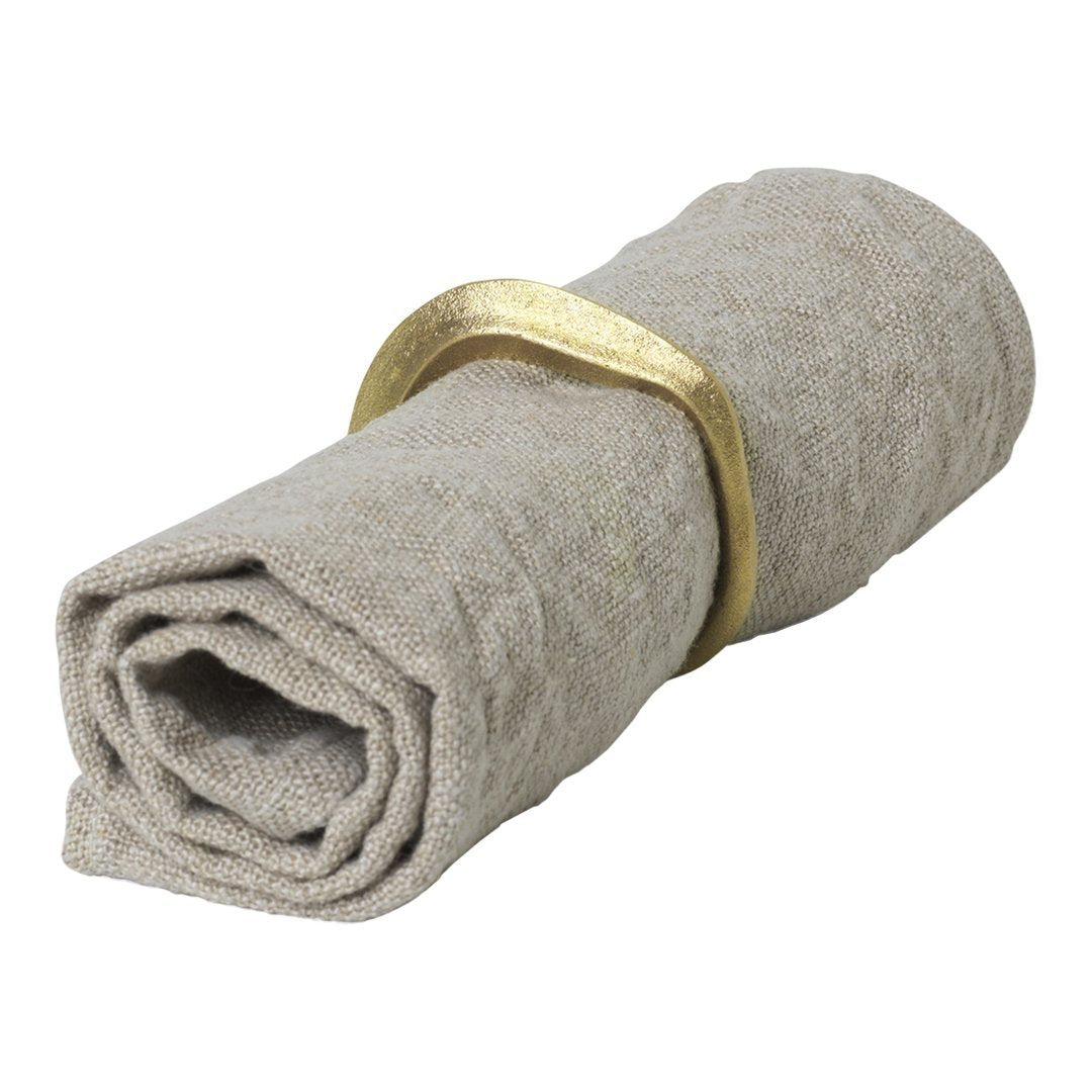 "Rolled linen napkin in soft beige with gold-tone napkin ring, featuring a subtle texture."