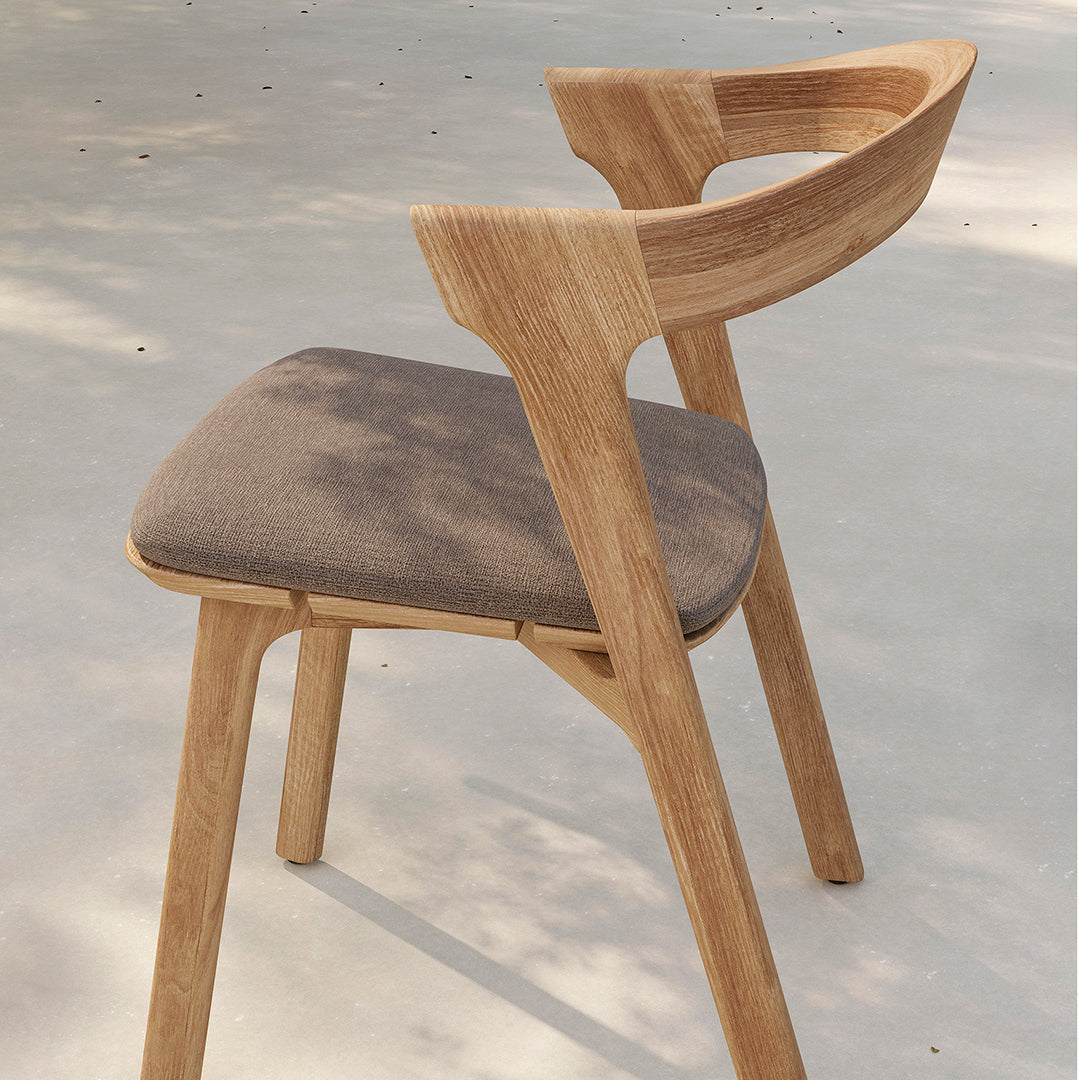 Light oak wooden chair with a grey upholstered seat, featuring a sleek, modern design and smooth contours.