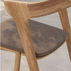 Light wood chair with a smooth grain and soft gray fabric seat, combining natural tones and textures.