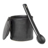 Black ceramic jar with a smooth matte finish and matching spoon, featuring a minimalist design.