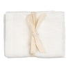Soft cream muslin blanket tied with a natural linen ribbon, featuring a smooth, solid texture. Perfect for cozy comforts.