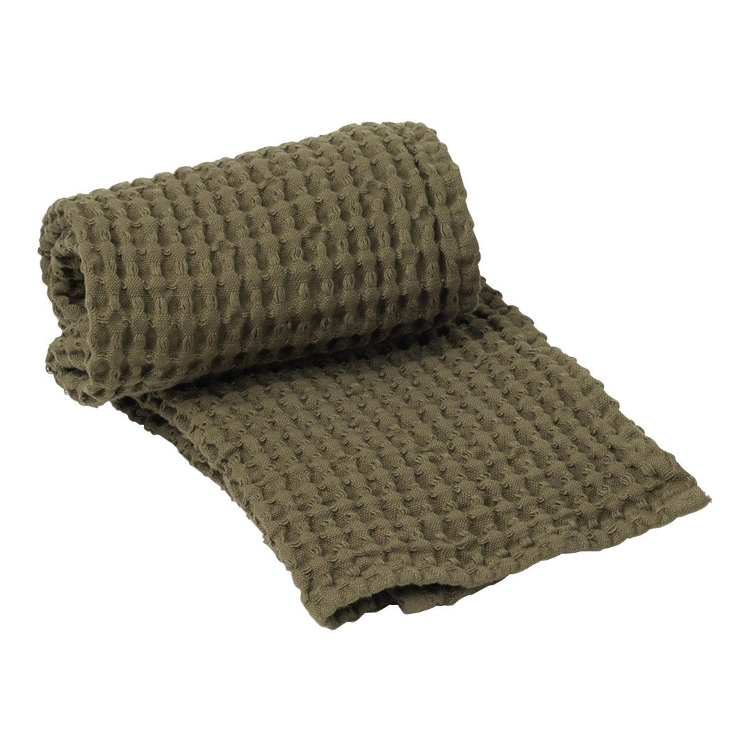 Olive green rolled textured blanket with a cozy waffle pattern, perfect for home décor and comfort.
