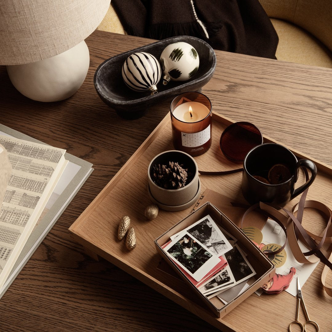 Decorative tray with a mix of earthy tones, black and white patterns, and warm candlelight accents.