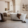 "Elegant white marble bathtub with a brown towel, soft beige tones, and neutral decor in a modern bathroom setting."