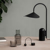 Stylish black lamp with geometric shades, glass vases in muted tones, and natural wood table. Modern decor essentials.