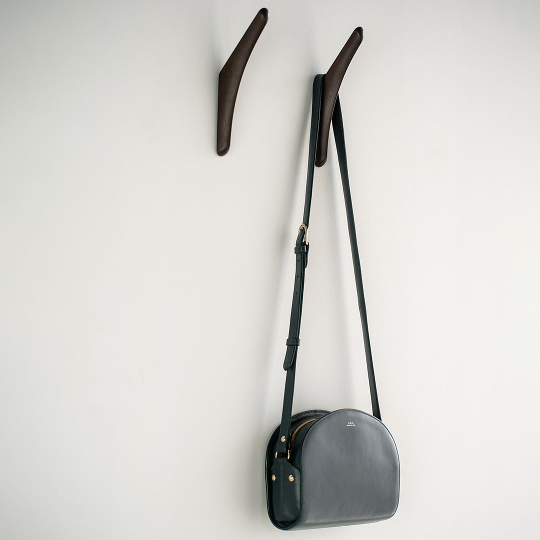 Gray crossbody bag with a sleek, minimalist design, featuring smooth textures and subtle accents. Ideal for any outfit.