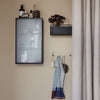 "Wall-mounted cabinet in black with a grid pattern; featuring a multicolored striped towel in soft blues and reds."