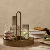 Elegant olive green tray with circular base, featuring minimalist glassware and textured stone accents.