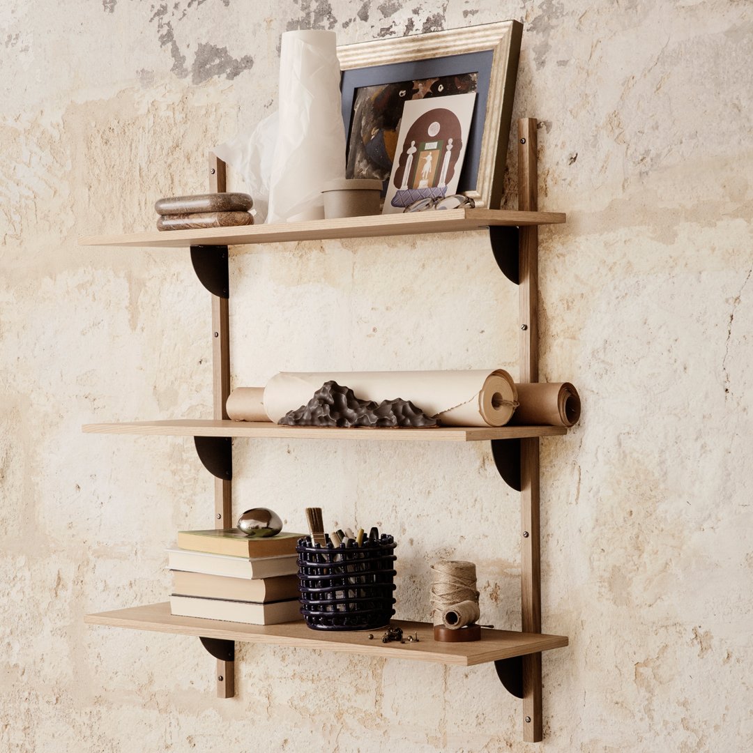 Natural wood shelves with a light finish, accented by black mounting brackets against a textured beige wall.