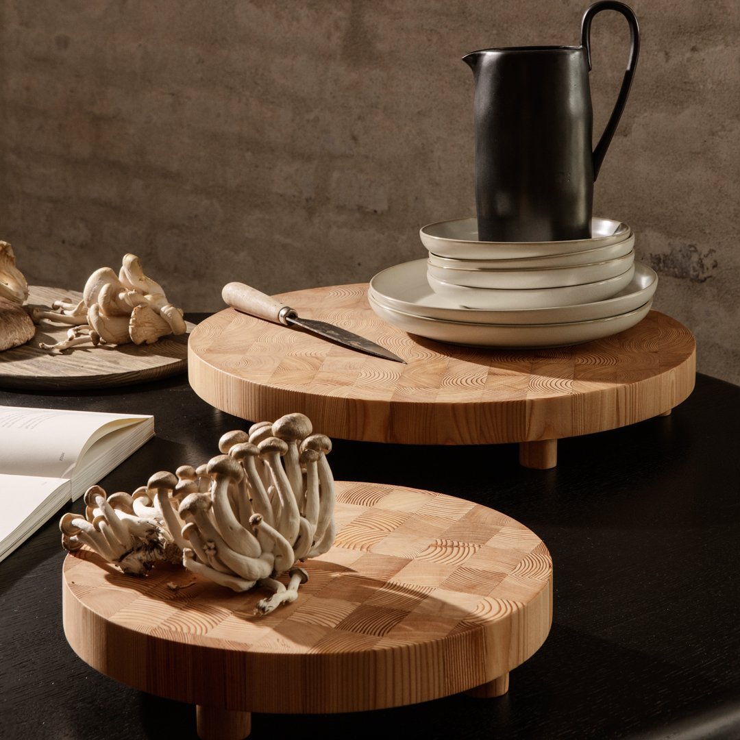 Bamboo serving boards with natural wood grain, featuring round shapes and a minimalist aesthetic.