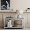 Modern light gray console table with a minimalist design, featuring textured beige storage bins and soft pastel accents.