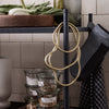 "Neutral-toned kitchen accessories with natural beige cords and dark gray textiles against a clean, tiled backdrop."