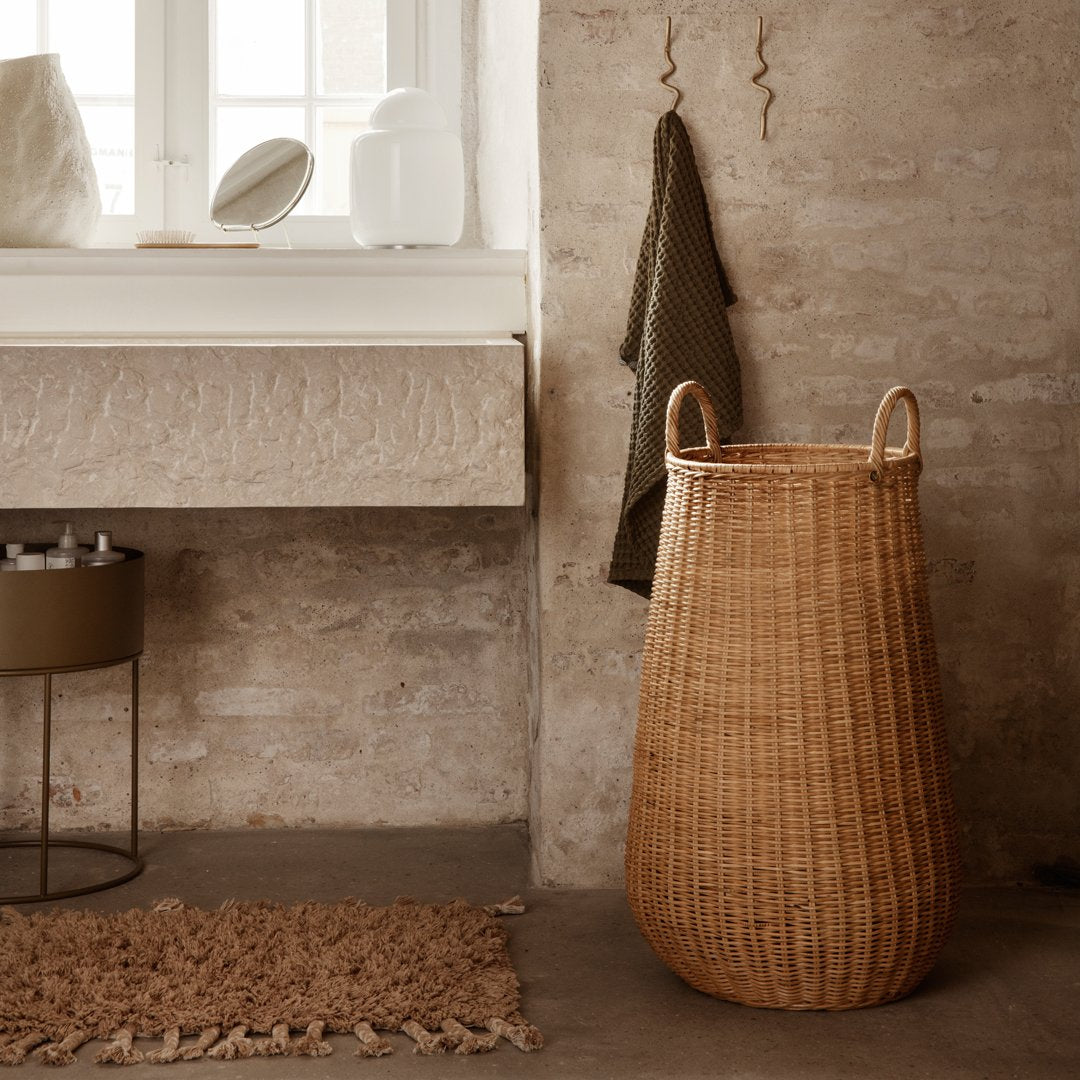 Natural woven basket in warm beige tones, featuring a smooth, curved pattern, complements earthy decor.