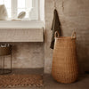Natural woven basket in warm beige tones, featuring a smooth, curved pattern, complements earthy decor.